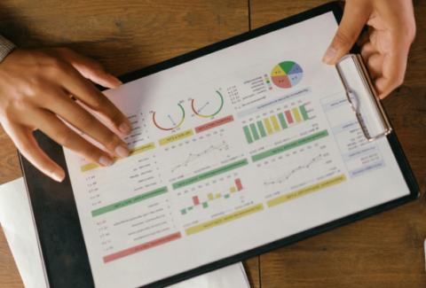 Inżynier jakości trzyma w dłoniach raport z kolorowymi wykresami, analizując wskaźniki jakościowe przed ich prezentacją w języku angielskim.